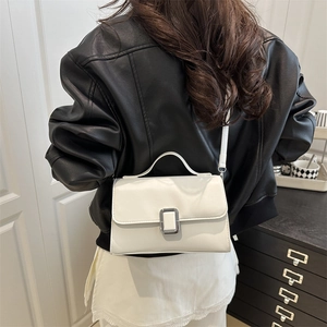 Minimalist white faux leather handbag with silver clasp shown on a shoulder model