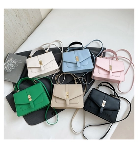 Flat lay of small PU leather crossbody bags in six vibrant colors with twist lock closures