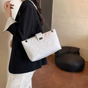 Borsa a tracolla bianca trapuntata con catena in metallo nero e chiusura a scatto su modella