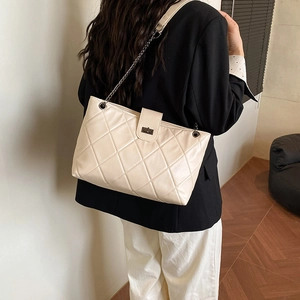 Elegante borsa trapuntata color crema con catena in metallo nero e chiusura minimale