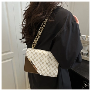 Detail of elegant shoulder bag with gold metal trim and chain strap on a vintage canvas