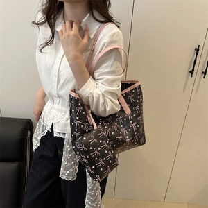 Black tote bag and coin purse set with pink bows and hearts pattern for travel