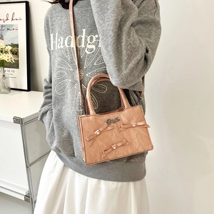 Sac à main rose avec nœuds 3D et perles sur une texture plissée élégante et moderne