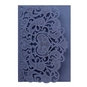 Detail of dark blue laser-cut wedding invitation featuring intricate floral hollow patterns