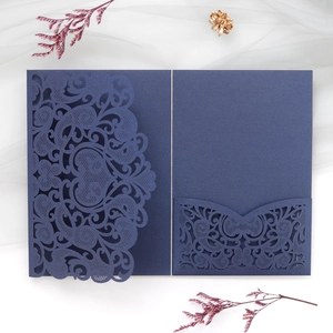 Detailed laser-cut navy blue wedding invitation cover with intricate floral patterns