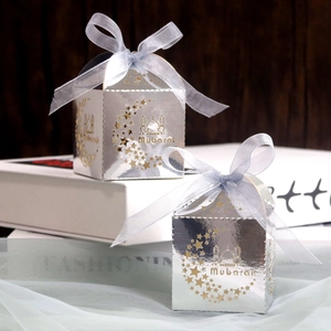 Detailed laser-cut silver candy box with Mubarak text, moon and star motifs and blue ribbon