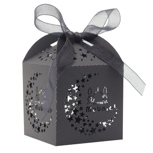 Detail of laser-cut black moon and star patterns on a Mubarak gift box with ribbon