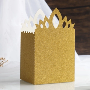 Close-up of glitter gold castle candy box with hollow crown design for wedding parties