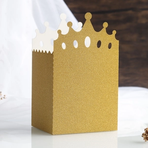 Detail shot of the glittering gold crown-shaped candy box with intricate cutout design