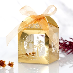 Detail of laser-cut gold Eid Mubarak candy box with ribbon and moon patterns