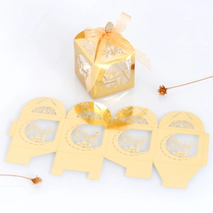 Macro view of gold laser cut Eid Mubarak favor box with mosque silhouette and ribbon bow
