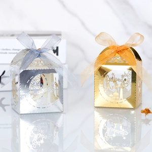Detailed macro of gold and silver Eid Mubarak favor boxes with ribbons and intricate cutouts