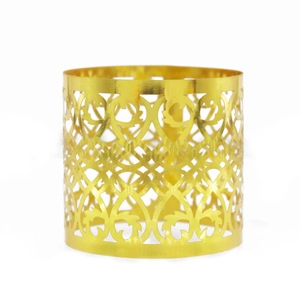 Macro view of a gold hollow napkin ring with intricate vine patterns and polished finish