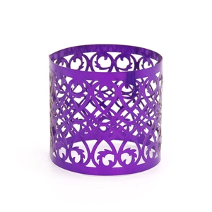 Macro detail of purple metallic napkin ring featuring an intricate hollowed floral pattern