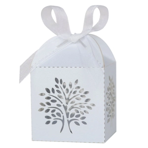 Detailed macro view of laser-cut tree design on ivory wedding favor candy box with ribbon