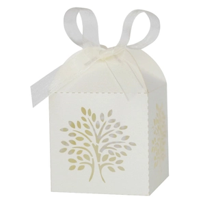Detail of ivory laser-cut tree candy box with white ribbon bow for wedding party decor