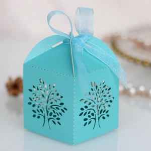 Close-up of light blue laser-cut candy box with tree design and satin ribbon bow