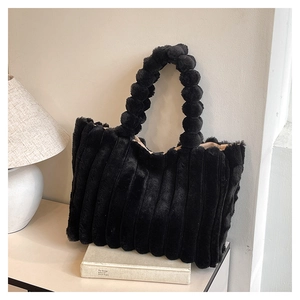 Detail of black faux fur tote bag showing striped plush texture and spherical handle