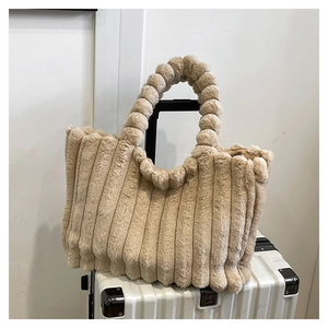 Detail of the soft plush tote bag with a unique textured strip design and round ball handle