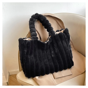 Detailed macro view of black plush tote bag featuring soft textured fur and bubble handles