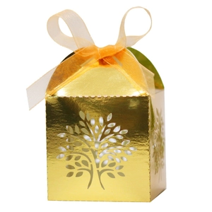 Detail of laser-cut tree design on golden favor box with a satin ribbon bow