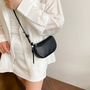 Minimalist black lychee texture crossbody bag with unique knot shoulder strap details