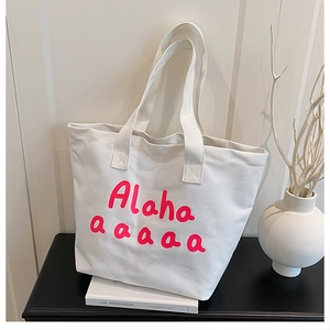 Gros plan d'un sac cabas en toile blanche avec un imprimé graphique Alaha rose vif
