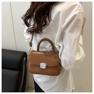 Detail of vintage brown leather handbag with silver rectangular lock and top handle