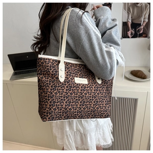 Détail du sac cabas léopard avec anses crème et logo de mode sur tissu résistant