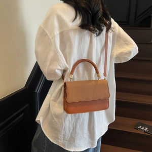Sac à main marron au design français avec texture tressée et bordure ondulée élégante