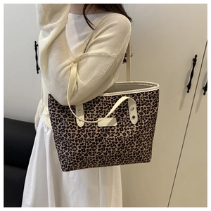 Détail du sac fourre-tout léopard avec anses en cuir blanc et étiquette de mode chic