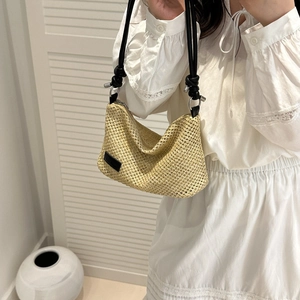 Chic woven straw shoulder bag in beige with black strap for summer vacation look