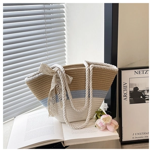Detail of tricolor woven tote bag with lace bow and sturdy white rope handles