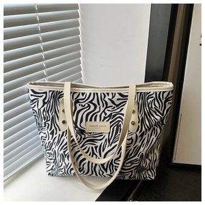 Détail du sac cabas imprimé zèbre avec poignée en cuir et logo mode sur le devant