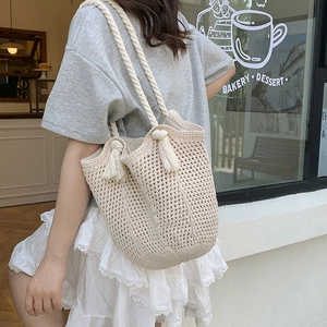 Grand sac cabas beige en coton tissé avec texture crochetée et anses à pompons