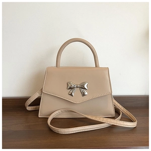 Detailed view of apricot PU leather handbag featuring a stylish silver metal bow buckle