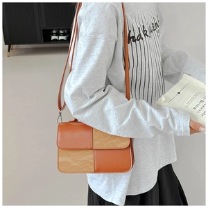 Detail of checkered orange and brown crossbody bag with unique crinkled leather texture