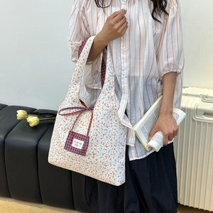 Florale Canvas-Tragetasche mit karierter Tasche in einer schicken Reiseszene
