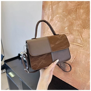 Detail of the vintage brown patchwork handbag with textured faux suede panel and silver buckle