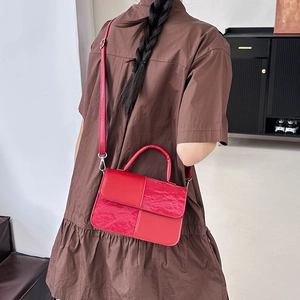 Fashionable red color-block crossbody bag with top handle shown on a model