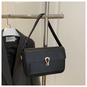 Détail du sac à bandoulière en cuir noir avec fermoir métallique géométrique doré