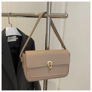 Détail du sac bandoulière en cuir marron clair avec fermoir rotatif en métal doré