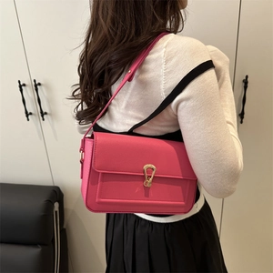 Sac à bandoulière fuchsia minimaliste avec boucle dorée et texture galet haut de gamme