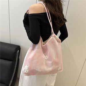 Pink marble tote bag with white lace floral embroidery shown by model in modern home setting