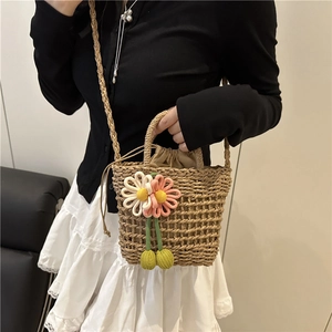 Handwoven straw bucket bag with 3D floral accents and drawstring lining for summer holidays