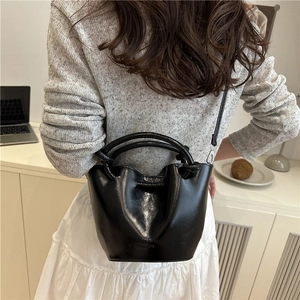 Fashionable black pleated bucket bag with dual handles and crossbody strap for women