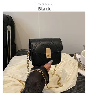 Close-up of black quilted mini bag with gold chain strap and turn-lock closure