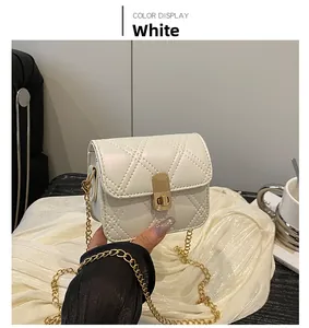 Close-up of white quilted mini crossbody bag with golden chain and metallic lock