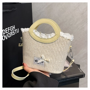 Gros plan du sac en paille beige avec bordure en dentelle blanche et écusson à nœud décoratif