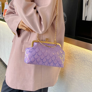 Retro purple sequin box handbag with gold chain strap worn over shoulder on pink suit